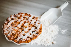 Delicious lattice-top pie on marble surface with scattered flour. jigsaw puzzle