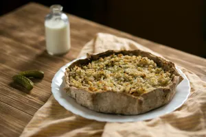 Warm rustic tart on a wooden table with a bottle of milk and pickles. jigsaw puzzle