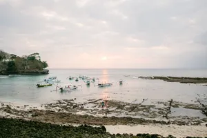 Serene scene of fishing boats at sunset with a rocky shoreline, capturing tranquil seaside beauty. jigsaw puzzle