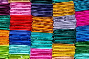 Vibrant and colorful stack of folded textiles in various hues, arranged neatly. jigsaw puzzle