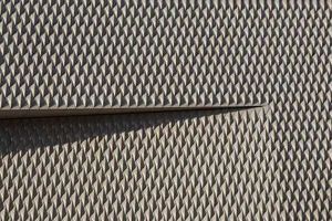 Modern building facade with geometric patterns casting shadows creating a dynamic visual effect. jigsaw puzzle