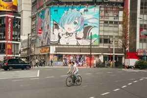 Street scene in Tokyo with anime billboard and cyclist crossing. jigsaw puzzle
