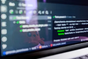 Close-up of a laptop screen displaying programming code with a cute plush toy reflecting. jigsaw puzzle