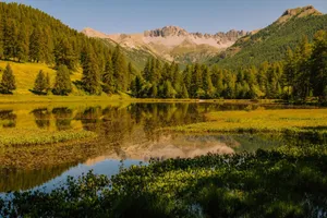 Tranquil lake reflecting mountains and pine trees in Cervières, France. jigsaw puzzle