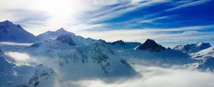 Stunning aerial view of snowy mountains in Tignes, France under a bright sky. jigsaw puzzle
