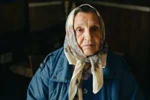 Portrait of an elderly woman wearing a headscarf indoors, showcasing wisdom and resilience. jigsaw puzzle