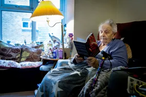 Elderly woman enjoying a book in a cozy living room, embracing retirement leisure time. jigsaw puzzle