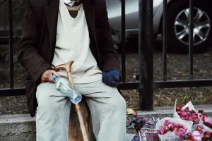 Elderly man sitting on a street with a cane and flowers in Tbilisi, Georgia. jigsaw puzzle