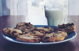 Chocolate chip cookies on a plate with a glass of milk, perfect breakfast treat. jigsaw puzzle