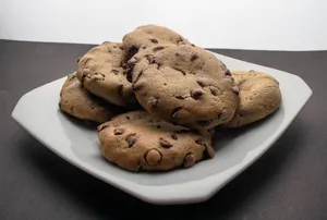Close-up of freshly baked chocolate chip cookies on a plate, perfect for dessert. jigsaw puzzle