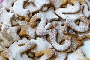 Close-up of star and number shaped cookies dusted with powdered sugar, perfect for holiday baking. jigsaw puzzle