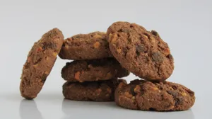 Close-up of six chocolate cookies stacked on white surface, perfect for any snack. jigsaw puzzle