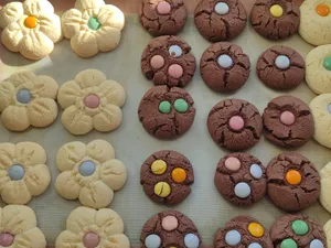 Assorted flower-shaped and chocolate cookies with colorful candies, perfect for parties and celebrations. jigsaw puzzle