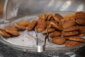 A variety of freshly baked cookies displayed with tongs in a bakery setting. jigsaw puzzle