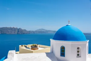 Iconic blue dome church in Santorini with a stunning view of the Aegean Sea. jigsaw puzzle