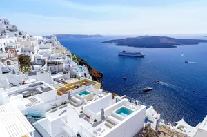 Breathtaking view of Santorini's white architecture and blue waters with cruise ships in the Aegean Sea. jigsaw puzzle