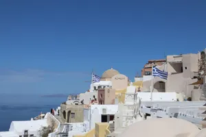 Breathtaking Santorini village of Oia with iconic Greek architecture and flags. jigsaw puzzle