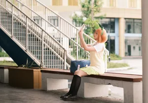 A young woman in cosplay costume takes a selfie on an outdoor bench, enjoying a sunny day. jigsaw puzzle