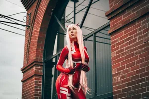 A cosplayer in a red costume poses confidently against a brick building. jigsaw puzzle