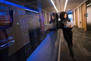 A woman using a laptop navigating a contemporary data center with mirrored servers. jigsaw puzzle