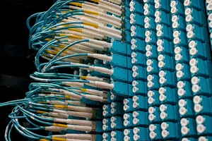 Detailed view of fiber optic patch cables connecting to a blue patch panel in a data center. jigsaw puzzle