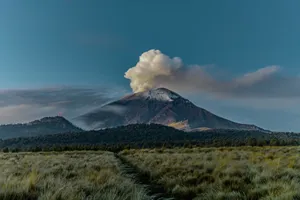 A stunning view of a volcano with smoke plumes under the early morning light, showcasing geological grandeur. jigsaw puzzle