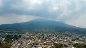 Cityscape with a misty volcano backdrop, captured from above, showcasing urban sprawl and natural beauty. jigsaw puzzle