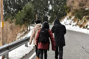Group walking on a snowy mountain road in winter, enjoying the cold outdoor adventure. jigsaw puzzle