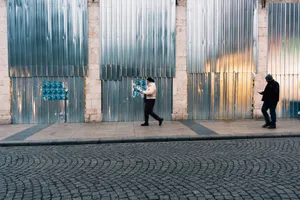 Two pedestrians walk along a metal-paneled street in Istanbul, Türkiye, on a day. jigsaw puzzle