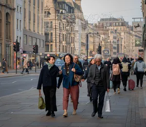 People walking along a bustling urban street with historic architecture in a European city. jigsaw puzzle
