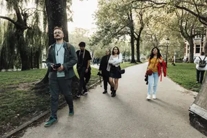A diverse group of photographers stroll through a tree-lined urban park, capturing the essence of leisure and creativity. jigsaw puzzle