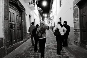 Group of people walking down a charming cobblestone street in Quito at night. jigsaw puzzle
