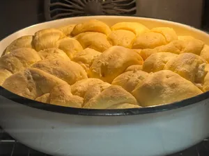 Close-up of fluffy, golden dinner rolls baking in the oven, showcasing a warm and inviting atmosphere. jigsaw puzzle
