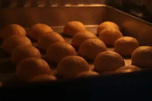 Golden buns baking in a warm oven setting, showcasing the art of bread-making. jigsaw puzzle