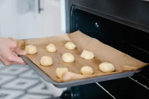 A close-up of unbaked dough balls on a tray, ready to be baked in a kitchen oven. jigsaw puzzle