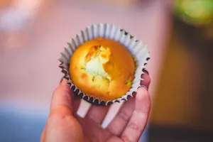 Delicious homemade muffin held in hand, perfect for a sweet snack. Showcases food's irresistible taste and texture. jigsaw puzzle