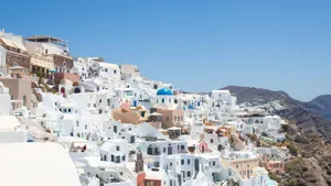 A captivating view of Santorini's iconic white buildings under a clear blue sky. jigsaw puzzle