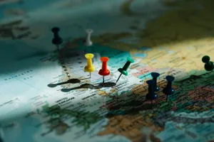 A close-up view of colorful push pins marking locations on a detailed world map. jigsaw puzzle