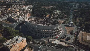 High angle drone shot of the Colosseum in Rome, Italy, showcasing its grandeur and surrounding urban landscape. jigsaw puzzle