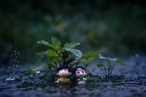 Cute toy figures under lush greenery during a rainfall, creating a whimsical scene. jigsaw puzzle