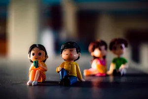 Small plastic figures of men with girlfriends in bright clothes sitting in shiny light on blurred background jigsaw puzzle