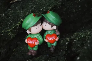 Two cute toy soldiers holding heart-shaped signs with 'love,' perfect for romantic or playful themes. jigsaw puzzle
