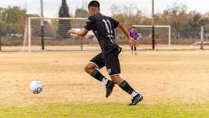 Soccer player dribbling the ball during a match on an outdoor field. jigsaw puzzle
