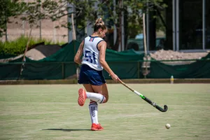 Athletic woman playing field hockey on sunny day, showcasing action and sports spirit. jigsaw puzzle