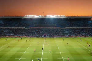 Exciting rugby game unfolding under stunning sunset in large stadium. jigsaw puzzle