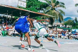 Players compete in an exciting outdoor basketball game with a lively crowd watching. jigsaw puzzle