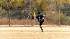 Soccer player skillfully kicks the ball during a match on an outdoor field. jigsaw puzzle