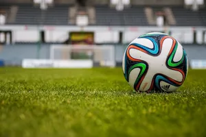 Vibrant soccer ball on a lush green field in an empty stadium. jigsaw puzzle