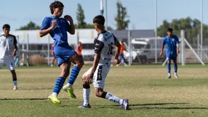 Players in blue and white uniforms compete fiercely during a sunny outdoor soccer match. jigsaw puzzle