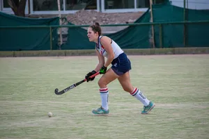 Focused female field hockey player in action during a game outdoors. jigsaw puzzle